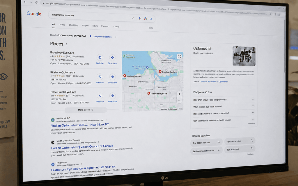 Computer monitor displaying Google search results for “optometrist near me” in a modern office setting.